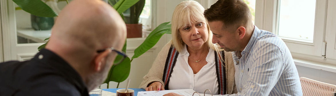 Mensen bespreken samen documenten tijdens een gesprek over praktische keuzes en voorbereiding.