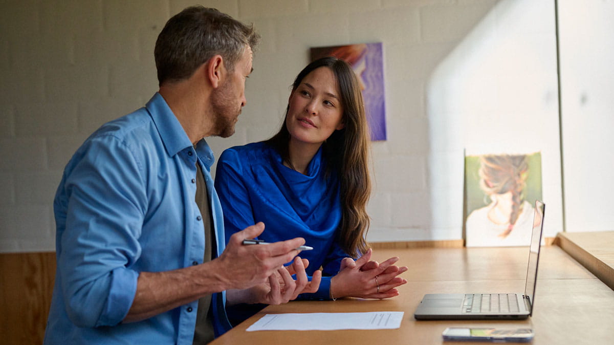 Homme et femme en discussion dans un bureau.